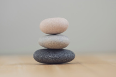 Harmony and balance, cairns, simple poise pebbles on wooden light white gray background, simplicity rock zen sculpture in daylight