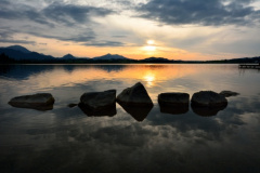 Rocks in lake Hopfensee of the Allgaeu during sunset (Bavaria, Germany).