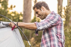 Two men erecting tent in forest, Deer Park, Cape Town, South Africa