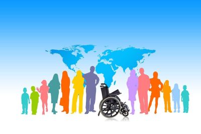 Cartoon world map with diverse people in rainbow colours, with a wheelchair in centre.