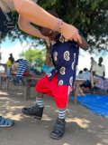 Peter, a young boy, is helped to stand in his new supportive boots.