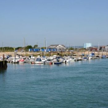 Littlehampton beach, the sea is in the foreground, a jetty and some boats are moored