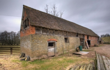 Stone barn with traditional wattle infill panels.
