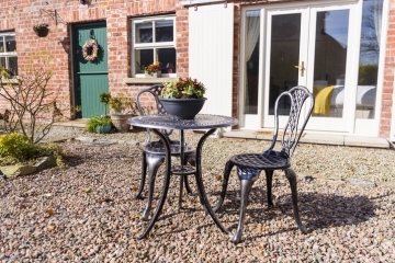 Cast iron table and chairs outside a converted barn